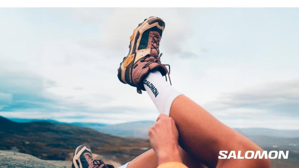 Paire de baskets Salomon de trail-running photographiée en extérieur, légèrement poussiéreuse, soulignant leur usage en randonnée.